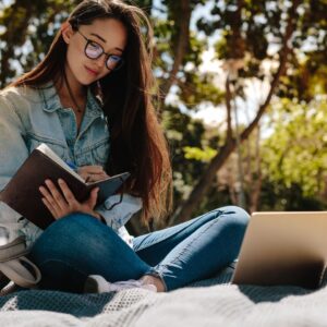 woman with glasses journaling