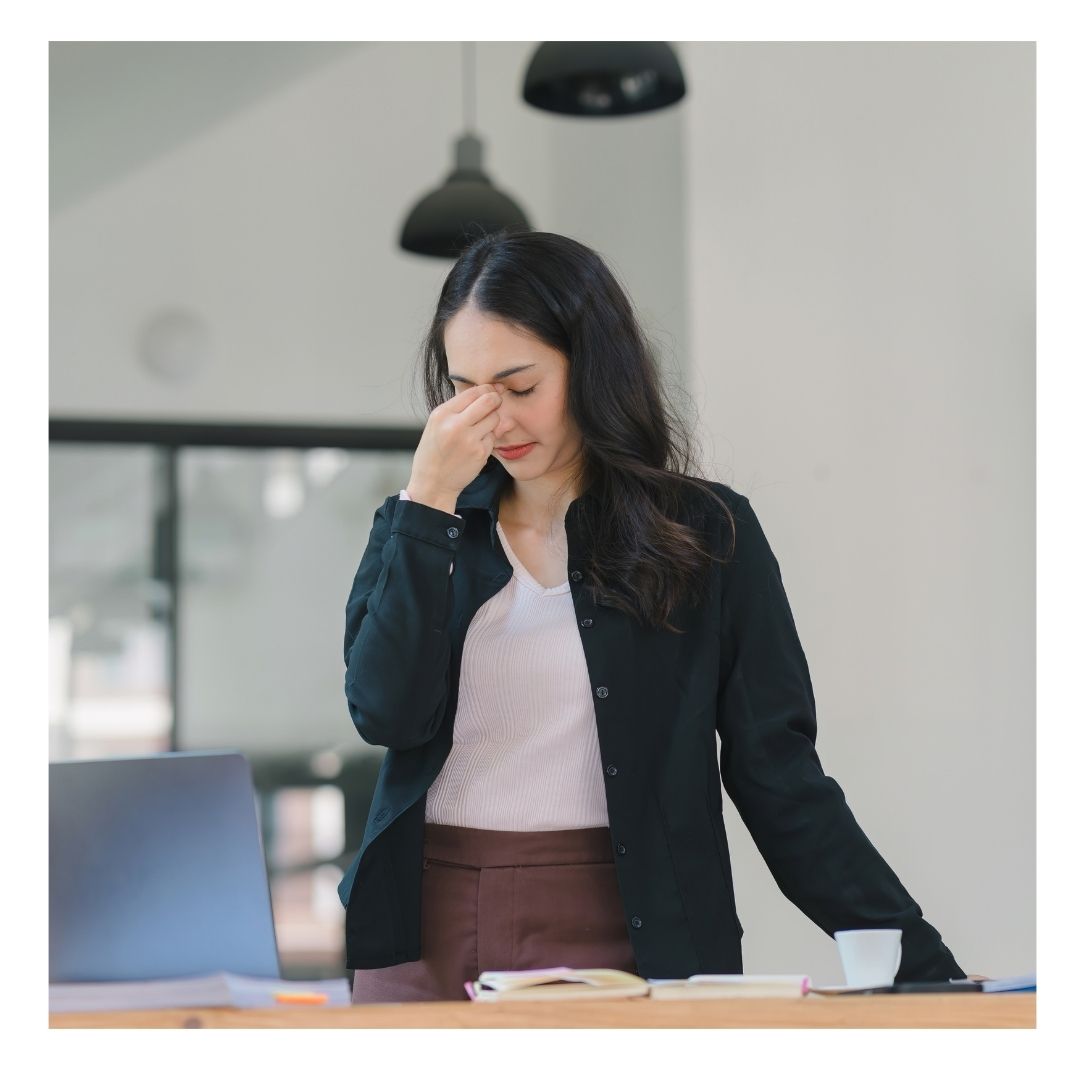 woman pinching the bridge of her nose