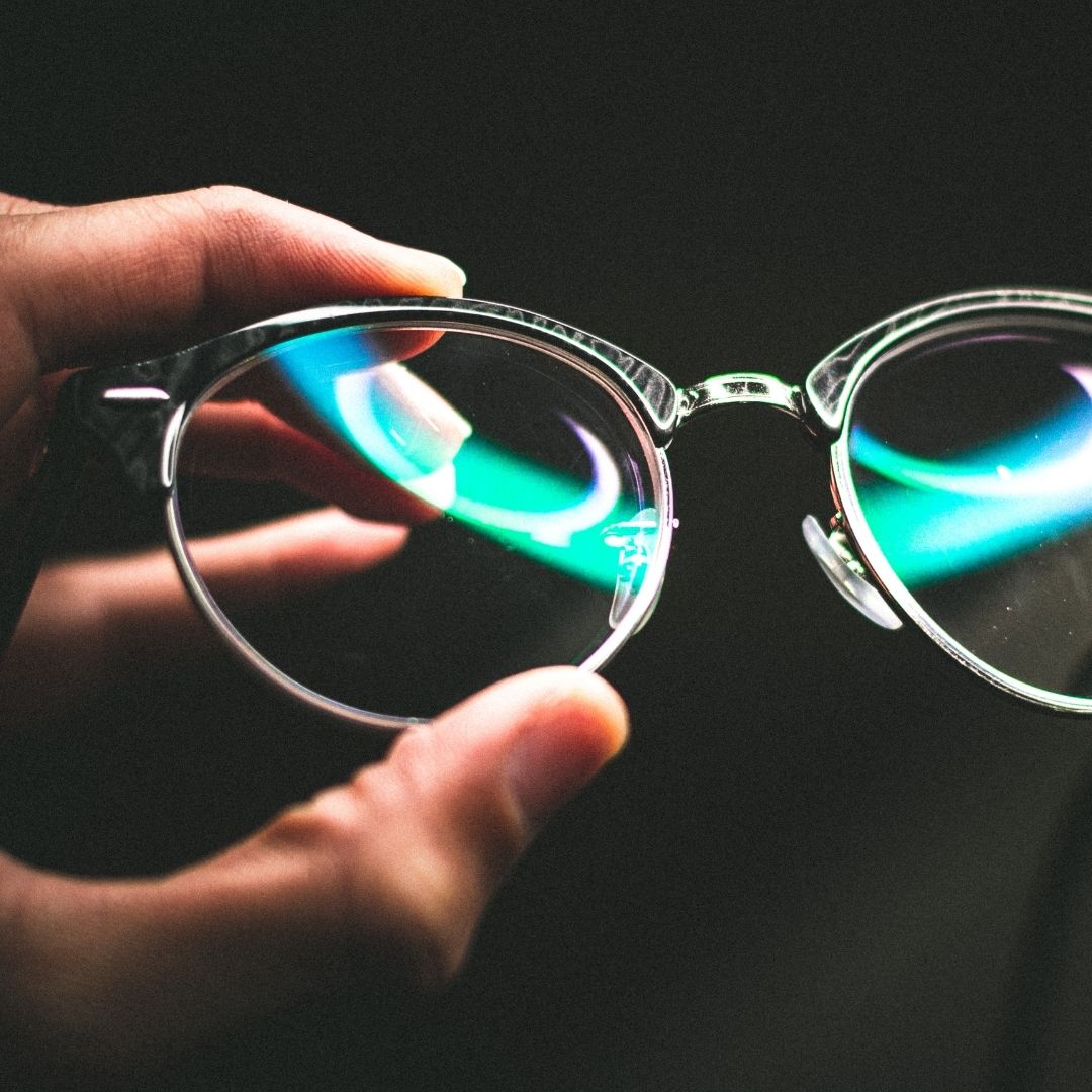 person holding clean eye glasses