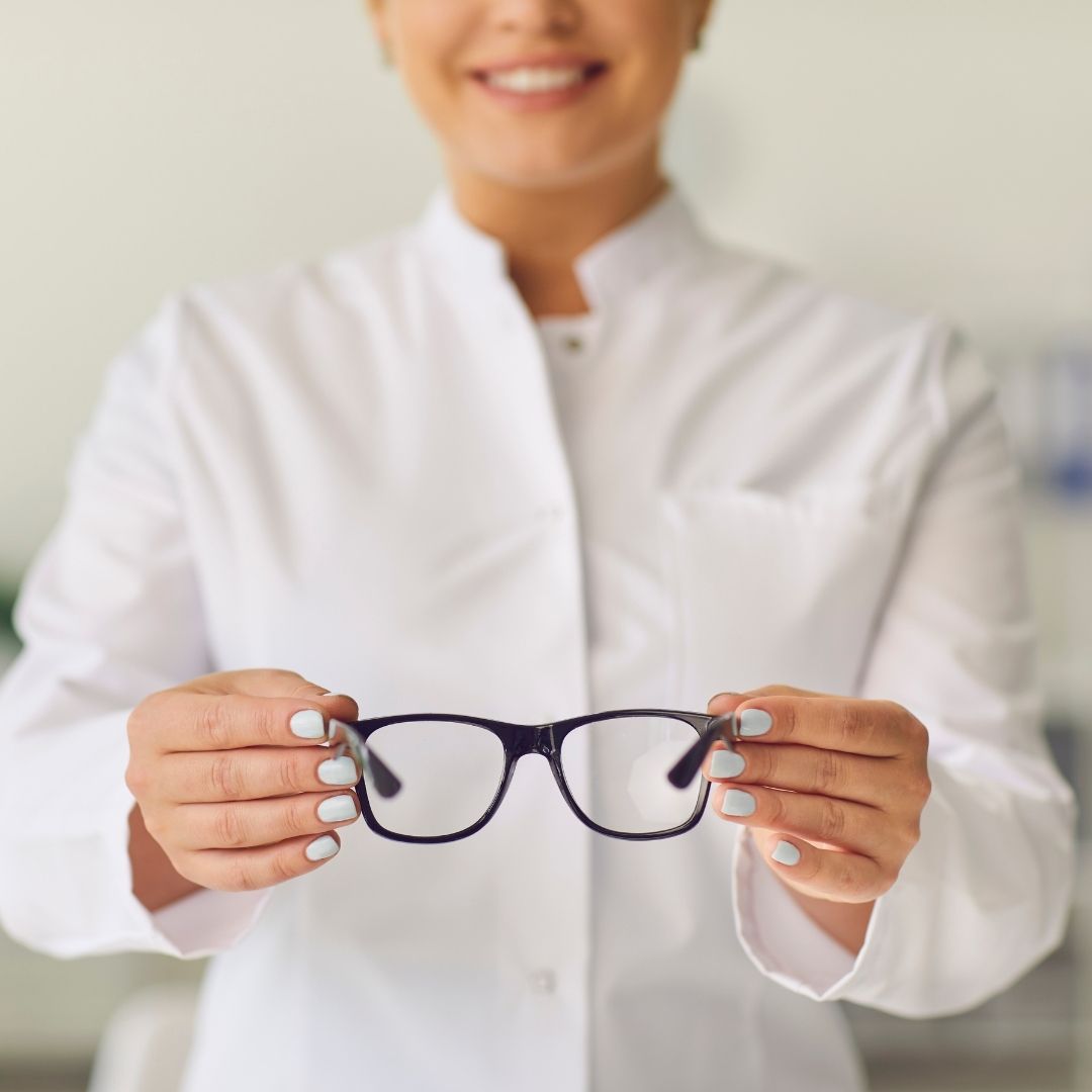 optometrist helping patient with glasses