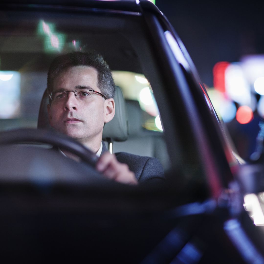 man driving at night wearing glasses