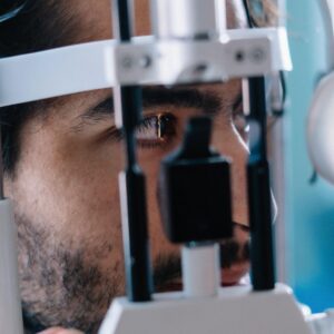 A patient undergoing a comprehensive eye health evaluation behind professional diagnostic equipment in Charleston.