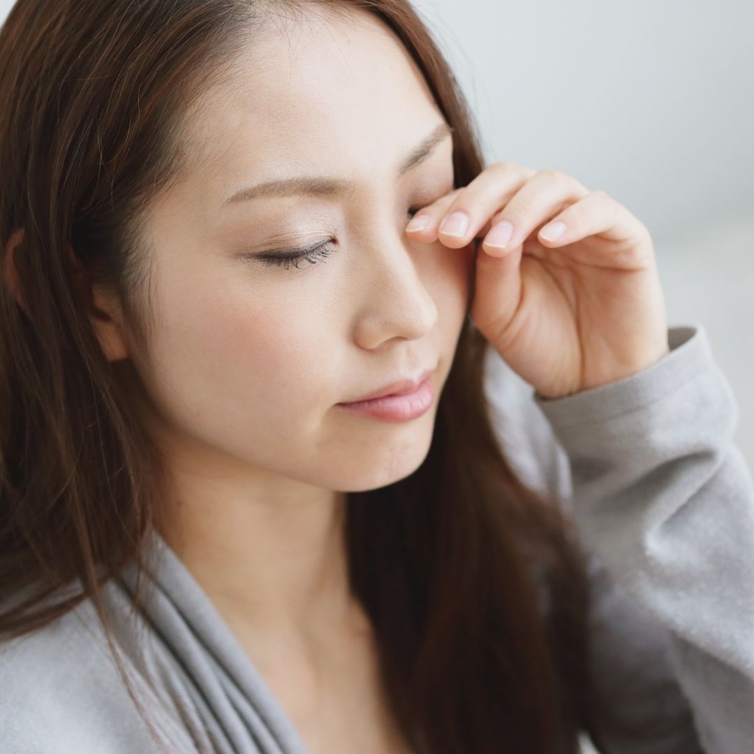 woman rubbing eyes with make up on